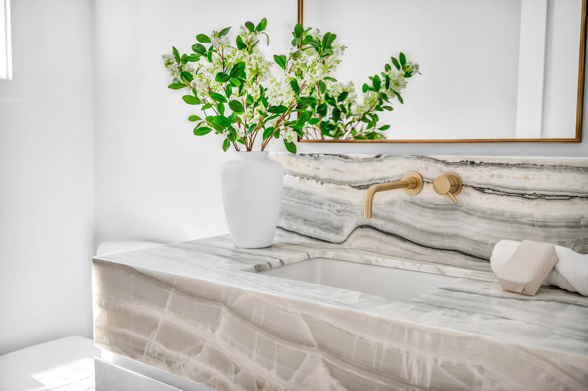 Polished white marble bathroom vanity with gold faucet restored by MarbleBLU on the Upper West Side of Manhattan